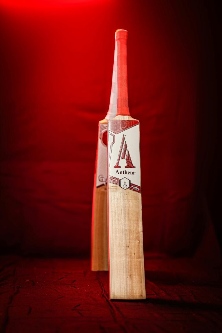 A striking image of a cricket bat illuminated by red light, showcasing sporting equipment.
